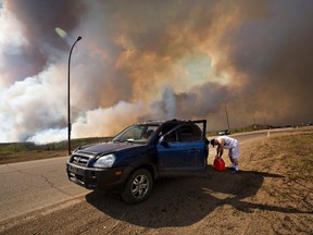 An evacuee puts gas in his car on his way out of Fort McMurray, Alta., on Wednesday May 4, 2016. (THE CANADIAN PRESS/Jason Franson)