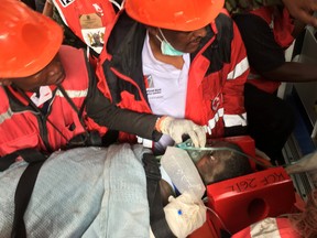 A woman is rescued from the rubble of a six-storey building that collapsed in Nairobi, Kenya, May 5, 2016. (REUTERS/Thomas Mukoya)