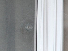A bullet hole is visible in a window after a townhouse on Munro St., near Dundas St. E. and Broadview Ave., was shot up early Thursday, May 5, 2016. (CHRIS DOUCETTE/TORONTO SUN)