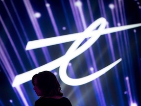 A woman is silhouetted as the Telus Corp. logo is displayed during a company event in Vancouver, B.C., on Friday October 2, 2015. (THE CANADIAN PRESS/Darryl Dyck)