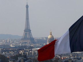 The French flag above the skyline of the French capital with the Eiffel Tower, The Invalides Dome and roof tops are seen from the colonnade of the Pantheon Dome in Paris, France, Friday, April 1, 2016.  (AP Photo/Francois Mori)