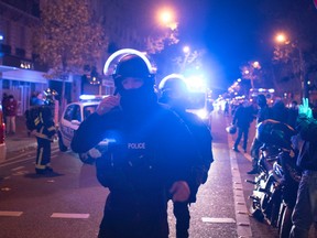 In this Friday, Nov. 13, 2015 file photo, elite police officers arrive outside the Bataclan theater after several dozen people were killed in attacks around Paris. A French Islamic State cell dismantled in the final stages of planning an attack has yielded a new secret in the first week of May 2016, with the release of undercover footage showing how a group of disaffected petty criminals transformed into a terror network. (AP Photo/Kamil Zihnioglu, File)