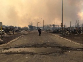 A Mountie surveys the damage on a street in Fort McMurray. Alberta RCMP