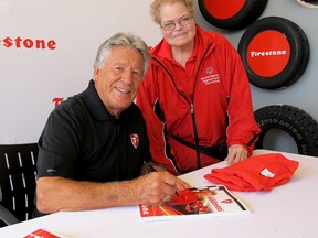 Car-racing luminary Mario Andretti poses with fan Sue Campanaro. Andretti, the only driver to win the Indianapolis 500, Daytona 500 and the Formula 1 title, was in Kingston on Thursday for a promotional visit to Fielding's Tire and Automotive Services on Princess Street.  Patrick Kennedy /The Whig-Standard/Postmedia Network