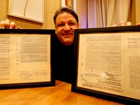 Mykalai Kontilai, owner of Collector's Cafe, with two of Jackie Robinson's 1940's baseball contracts. Michael Peake/Toronto Sun/Postmedia Network