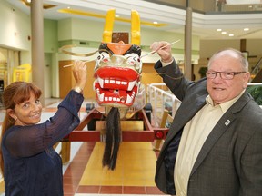 Tannys Laughren, executive director of the Northern Cancer Foundation, and Greater Sudbury Mayor Brian  Bigger dot the eyes during a ceremony at the media launch of the Sudbury Dragon Boat Festival at the Rainbow Centre in Sudbury, Ont. on Thursday May 5, 2016. The cancer foundation and the Sam Bruno P.E.T. Scan Fund have been selected as the pledge beneficiary of this year's festival. John Lappa/Sudbury Star/Postmedia Network