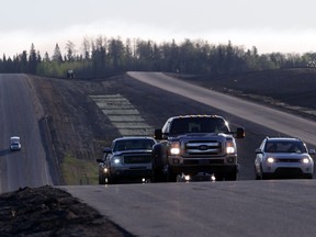 A convoy of cars sporadically heads South down Highway 63 after being stranded at a work camp north of Fort McMurray, Alberta on May 6, 2016. AFP PHOTO/Cole Burston