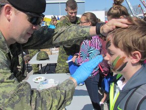 Trooper Macauley Clegg applies camouflage paint on the face of Iain Thompson, a Grade 6 student at Queen Elizabeth II Public School in Petrolia on Friday May 6, 2016 during an Emergency Preparedness Day at the Clearwater Arena in Sarnia, Ont. (Paul Morden, The Observer)