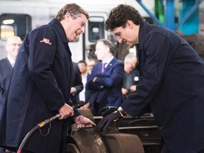 Prime Minister Justin Trudeau, right, and Toronto Mayor John Tory use power tools on a TTC subway car at the Greenwood Subway Yard in Toronto on Friday, May 6, 2016. THE CANADIAN PRESS/Nathan Denette