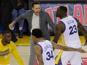 Warriors guard Stephen Curry (top left) celebrates with guard Ian Clark (bottom left) forward Draymond Green (23) and guard Shaun Livingston (34) during Game 2 of a second-round NBA playoff series against the Trail Blazers in Oakland, Calif., on Tuesday, May 3, 2016. (Jeff Chiu/AP Photo)