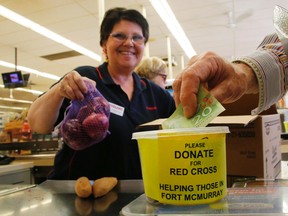 Cashier Lee Evelyn is all smiles as she collects donations for Fort McMurray wildfire victims on Friday May 6, 2016 at Lakefield Foodland in Selwyn Township, Ont. (Clifford Skarstedt/Peterborough Examiner/Postmedia Network)