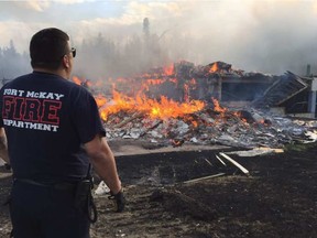 Ron Quintal, deputy chief of the Fort McKay volunteer fire department, watches a home burn after arriving in Abasand on Wednesday, May 4, 2016.
