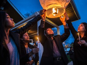 John Mullapudi (M) with his wife Shobha Mullapudi (L) along with their two daughters release a lantern at a vigil for their daughter Cynthia Mullapudi on May 6, 2016. (CRAIG ROBERTSON, Toronto Sun)