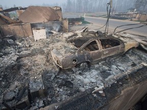 Home foundations and shells of vehicles are nearly all that remain in a residential neighbourhood destroyed by a wildfire on May 6, 2016 in Fort McMurray.