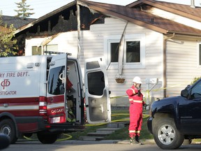 Calgary firefighters and police investigate at the scene of a fire in Falconridge where five people have died in Calgary, Alta on Saturday May 7, 2016. The house in this image is next door to the house where heavy damage occurred. (Jim Wells/Postmedia Network)