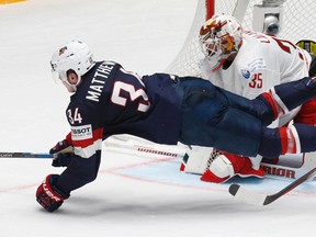 Auston Matthews of the United States, bottom, falls as he attacks the net of goalkeeper Kevin Lalande of Belarus during the world championship in St.Petersburg, Russia, Saturday, May 7, 2016. (AP Photo/Dmitri Lovetsky)
