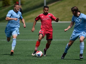 Fury FC forward Paulo Junior (7) dribbles against Minnesota United FC players Justin Davis (2) and Brent Kallman (6) at TD Place on May 7. (James Park, Postmedia Network)