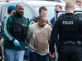Police take Eulalio Tordil, 62, a suspect in three fatal shootings in the Washington, D.C., area into custody in Bethesda, Md., Friday, May 6, 2016. Tordil is an employee of the Federal Protective Service, which provides security at federal properties. He was put on administrative duties in March after a protective order was issued against him. (AP Photo/Alex Brandon)