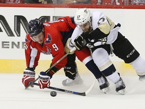 Washington Capitals defenceman Dmitry Orlov (9) and Pittsburgh Penguins winger Bryan Rust (17) battle for a loose puck during Game 5 Saturday, May 7, 2016 in Washington. (AP Photo/Pablo Martinez Monsivais)