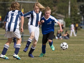 Fort McMurray Fury player Clark Sandaluk, right, battles players from the West Edmonton Warriors Soccer Club during a tournament at Westbrook School on Saturday, May 7, 2016. The Fury players were clad in donated soccer cleats, pads, and jerseys.