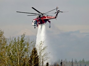FORT MCMURRAY, ALBERTA: MAY 8, 2016 - A helicopter battles a wildfire south of Fort McMurray, Alberta on May 8, 2016. The wildfire has consumed over 200,000 hectares of forest and forced the evacuation of 88,000 people from Alberta's fourth largest city. (PHOTO BY LARRY WONG/POSTMEDIA NETWORK)