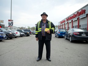 Denis Dimitrakopoulos fills out a parking slip in the Hanford's Tire parking lot before a London Knights hockey game at nearby Budweiser Gardens in London, on Saturday. (CRAIG GLOVER, The London Free Press)