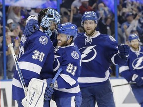 Tampa Bay Lightning's goalie Ben Bishop is congratulated by Jonathan Marchessault and Victor Hedman at the end of the third period of Game 5 of the NHL hockey Stanley Cup Eastern Conference semifinals against the New York Islanders. (AP Photo/Chris O'Meara)