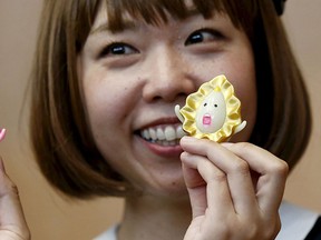 Japanese artist Megumi Igarashi, known as Rokudenashiko, holds her vagina-inspired artworks after a news conference following a court appearance in Tokyo April 15, 2015. REUTERS/Toru Hanai