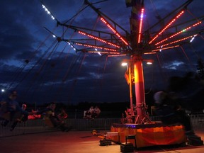 Carnival-goers fly through the air on a swing ride in this file photo taken on September 5, 2015 in Fort McMurray Alta. (Robert Murray/Fort McMurray Today/Postmedia Network)