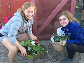 Wawanosh 4-H members Loretta Higgins and Amanda Morrison showcase their freshly made flowerpots.