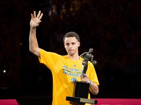 Golden State Warriors guard Stephen Curry (30) hoists the MVP trophy before game two of the second round of the NBA Playoffs against the Memphis Grizzlies at Oracle Arena. (Kyle Terada-USA TODAY Sports)
