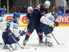 Finland's Atte Ohtamaa (left) and Antti Pihlstrom (right) fight for the puck with Jordan Schroeder (second left) and Auston Matthews (second right) of the United States during the world hockey championship in St. Petersburg, Russia, on Monday, May 9, 2016. (Dmitri Lovetsky/AP Photo)