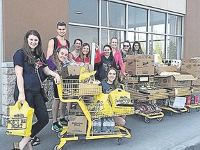 The Kingston Pegasus U18 girls volleyball team, displaying some of the collected gift cards, assisted Fort McMurray evacuees in Edmonton last week when they were there for a national tournament. The team raised more than $7,000 from donations back home and distributed food and supplies to those fleeing the fire in wildfires in the Fort McMurray region. (Submitted Photo)