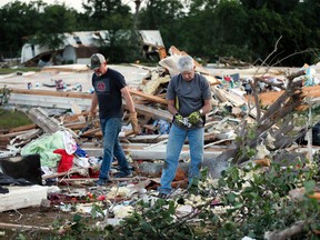 Kenny Baker, right, and Tony Scheuerman help to clean up after a tornado destroyed the home of Lisa Buckner, not pictured, west of Wynnewood, Okla., in rural Gavin County, Monday, May 9, 2016. Storms swept through the nation's midsection Monday, spawning numerous tornadoes. (Nate Billings/The Oklahoman via AP)