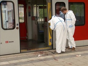 Police investigators look at bloodstained footprints leading out of a train and on a platform following a knife attack in Grafing train station, south east of Munich, Germany, in this still image taken from video on May 10, 2016. (REUTERS TV)