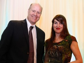 Former Times-Journal co-op student Amy Kenny is presented the Journalist of the Year trophy by event sponsor Paul Berton at the Ontario Newspaper Awards in Hamilton last month. Kenny, now a reporter at the Hamilton Spectator, won three awards at the 62nd annual celebration last month.