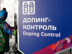 A man walks past a sign reading doping control, at the biathlon and cross-country ski centre during the 2014 Winter Olympics in Krasnaya Polyana, Russia, on Feb. 21, 2014. The World Anti-Doping Agency will investigate Russian doping allegations relating to the Winter Games in Sochi. (Lee Jin-man/AP Photo/Files)