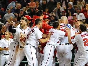 Nationals right fielder Bryce Harper (left) reacts towards home plate umpire Brian Knight (not pictured) as first baseman Clint Robinson (25) is greeted by teammates after hitting walk off homer against the Tigers during the ninth inning at Nationals Park in Washington on Monday, May 9, 2016. (Brad Mills/USA TODAY Sports)