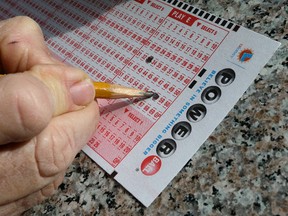 In this Jan. 12, 2016 file photo, a lottery player fills out numbers on a Powerball form in Oakland, Calif.  (AP Photo/Ben Margot, File)