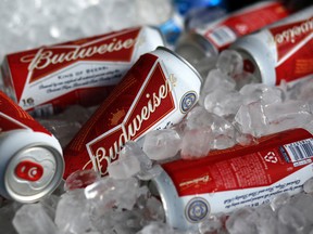 In this Thursday, March 5, 2015, file photo, Budweiser beer cans are seen at a concession stand at McKechnie Field in Bradenton, Fla. The world's two biggest beer makers will join forces to create a company that produces almost a third of the world's beer, as Budweiser maker AB InBev announced Wednesday, Nov. 11, 2015, a final agreement to buy SABMiller for 71 billion pounds ($107 billion). But in the U.S., the deal will not bring arch rivals Budweiser and Miller under the same roof. (AP Photo/Gene J. Puskar, File)