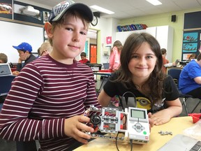 Evergreen Elementary School Grade 4 students Owen Nelson (left) and Aliyah Tuttle (right) show off a robot they made in class.