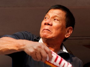 Rodrigo "Digong" Duterte throws election souvenir shirts to his supporters during election campaigning in Malabon, Metro Manila in the Philippines April 27, 2016.    REUTERS/Erik De Castro/File Photo