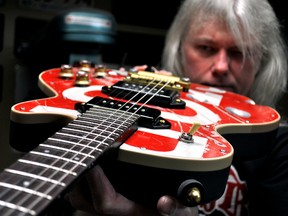 John Burgess holds a custom guitar in his home workshop in London Ont. May 5, 2016. CHRIS MONTANINI\LONDONER\POSTMEDIA NETWORK