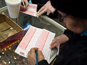 A woman fills out a Mega Millions lottery ticket at a tobacco shop on Broadway, in New York, March 30, 2012. (REUTERS/Andrew Burton)