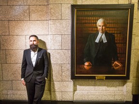 Paul Wyse, an Osgoode artist who was commissioned to paint a portrait of former prime minister, Paul Martin, stands beside his portrait of former Speaker Peter Milliken. Darren Brown/Postmedia
