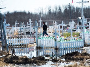 An indigenous person visits the cemetery in the Northern Ontario First Nations reserve in Attawapiskat, on Tuesday, April 19, 2016.