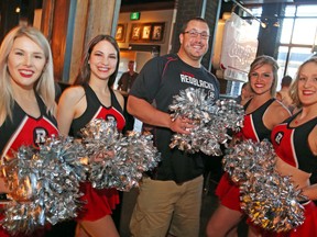 Redblacks offensive lineman Alex Mateas is joined by four of the team’s cheerleaders at the draft party at Jack Astor’s. (Jean Levac, Postmedia Network)