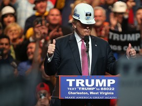 U.S. Republican Presidential candidate Donald Trump models a hard hat in support of the miners during his rally at the Charleston Civic Center on May 5, 2016 in Charleston, W.Va. (Photo by Mark Lyons/Getty Images)