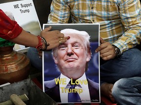 A priest applies a "tika" on the portrait of Republican U.S. presidential candidate Donald Trump, during a special prayer organized by Hindu Sena, a Hindu right-wing group, to ensure his victory in the upcoming elections, according to a media release, in New Delhi, India, on May 11, 2016. (REUTERS/Anindito Mukherjee)