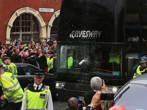 A drink can hits the screen of the Manchester United team bus as it arrives for the English Premier League match against West Ham United at Upton Park, London, Tuesday May 10, 2016. (Nick Potts/PA via AP)